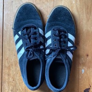 Adidas black shoes with white strips.